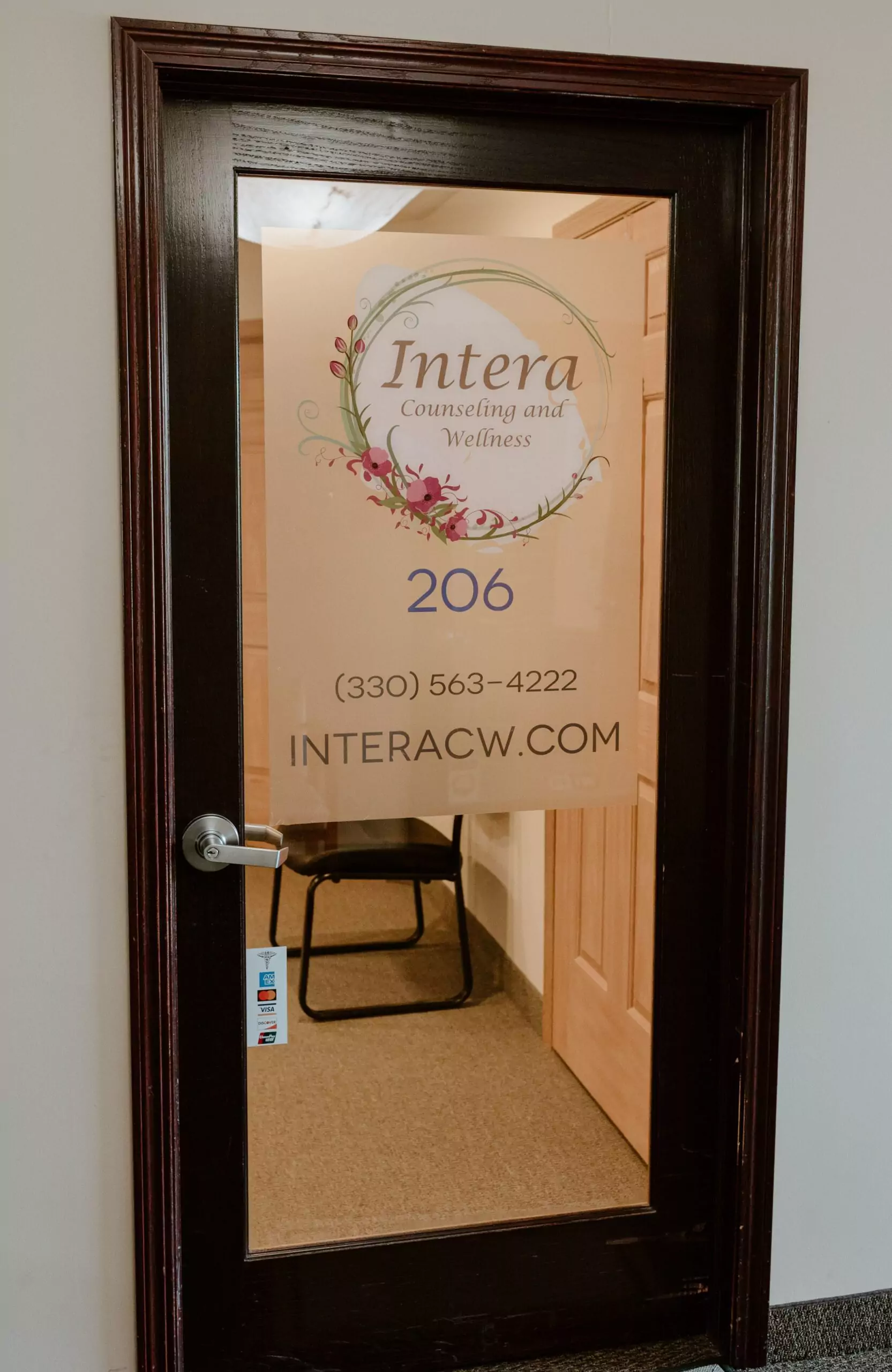 Door into Intera's office. Brown frame with clear glass. The Intera logo is on the top of the glass with the office number (206) under the logo.